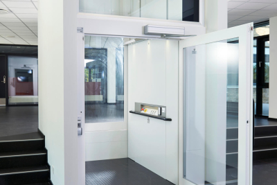 Een platform rolstoel lift wit die met de deur open staat Een platform rolstoel lift wit die met de deur open staat